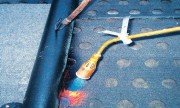 Rozłożoną na oczyszczonym betonowym podłożu papę podkładową możemy mocować łącznikami mechanicznymi lub zgrzewać – papa musi być przeznaczona do określonego sposobu mocowania.